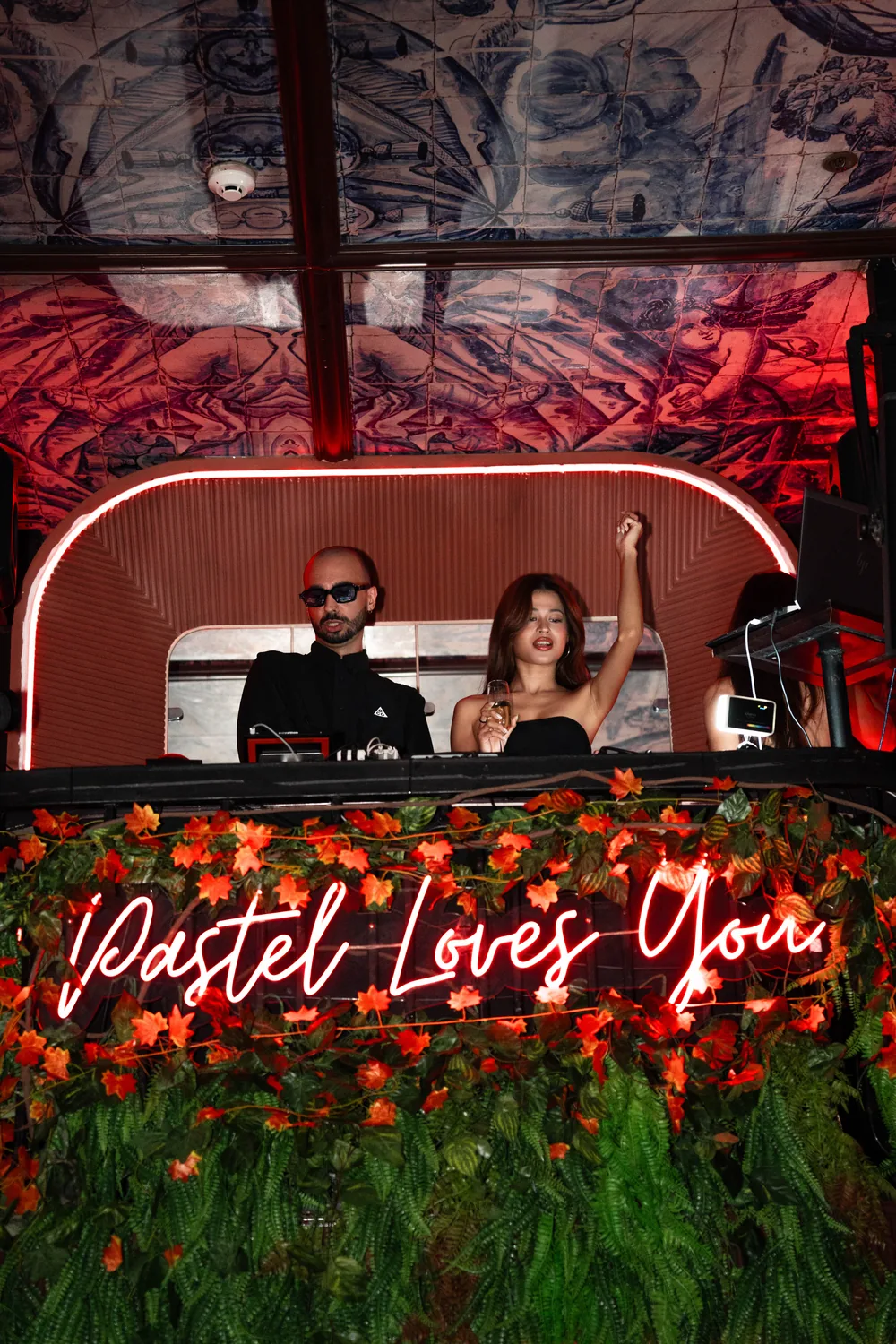 DJ aux platines sous l'enseigne néon Pastel Loves You