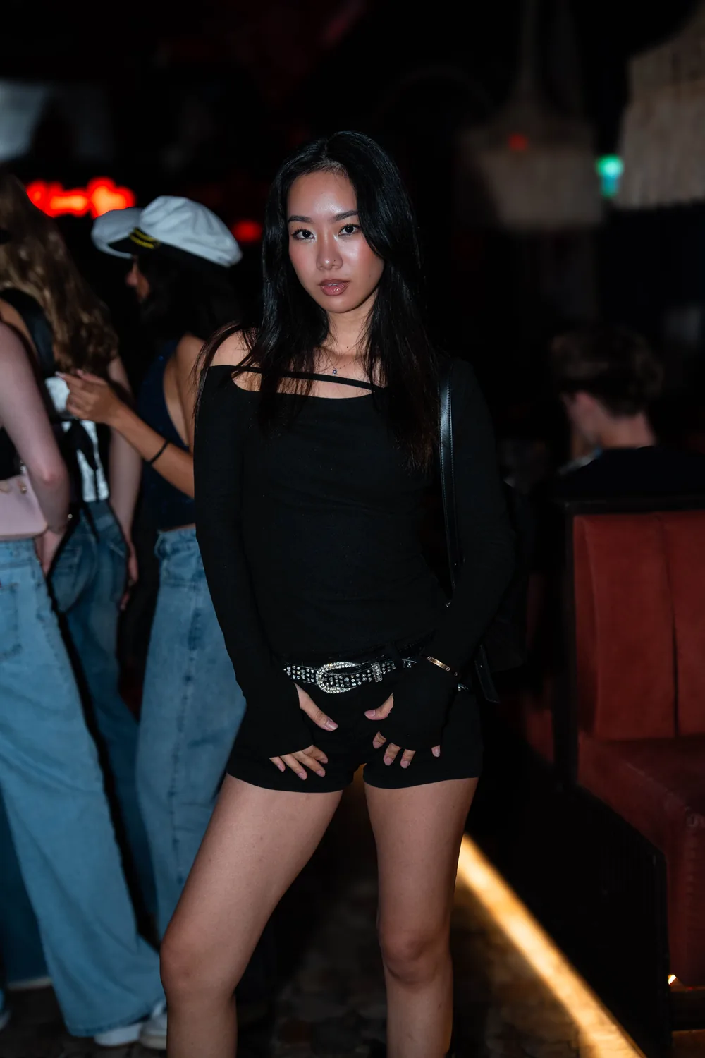 Portrait de modèle en total look noir dans un club de Bangkok, néons rouges